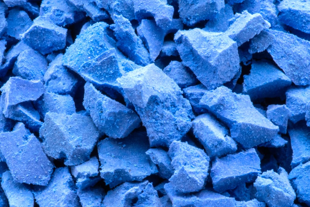 Macro photograph of granulated EPDM granules with torn, dusty, irregular faces