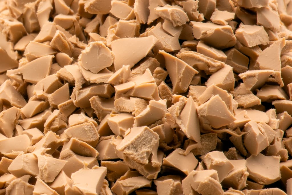 Macro photograph of Rosehill TPV granules with smooth, clean, pore-free faces, at the same scale