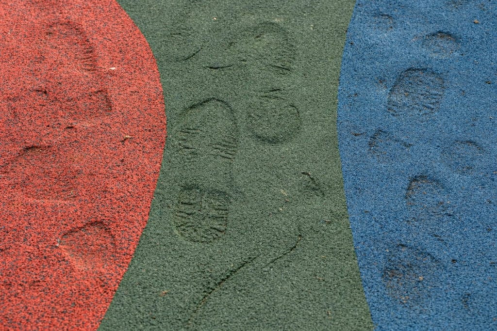 Permanent footprint impressions compressed into a commodity TPE-V playground surface during summer heat